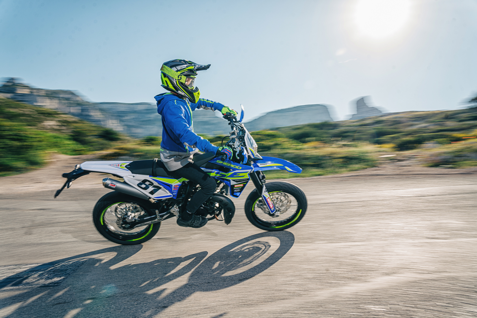 Piloto joven con una Sherco 50 SM en una carretera de montaña